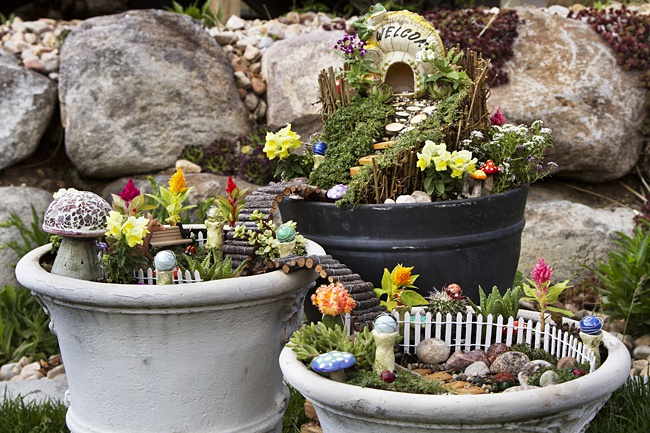 image of kids fairy garden in pots on patio 