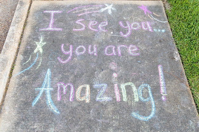 image of message written for kids on concrete pavement chalk 