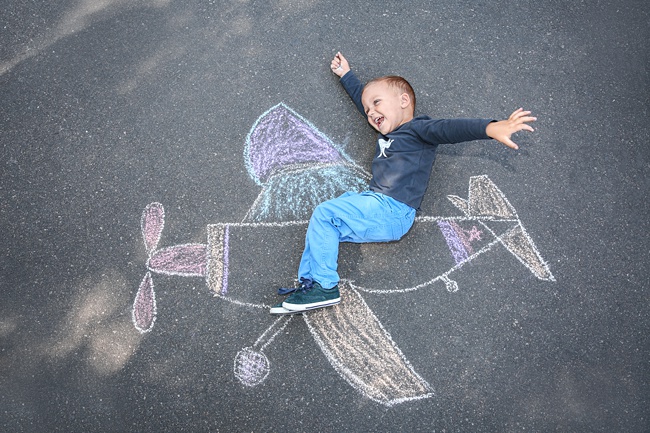 image of pavement chalk drawing child on patio having fun